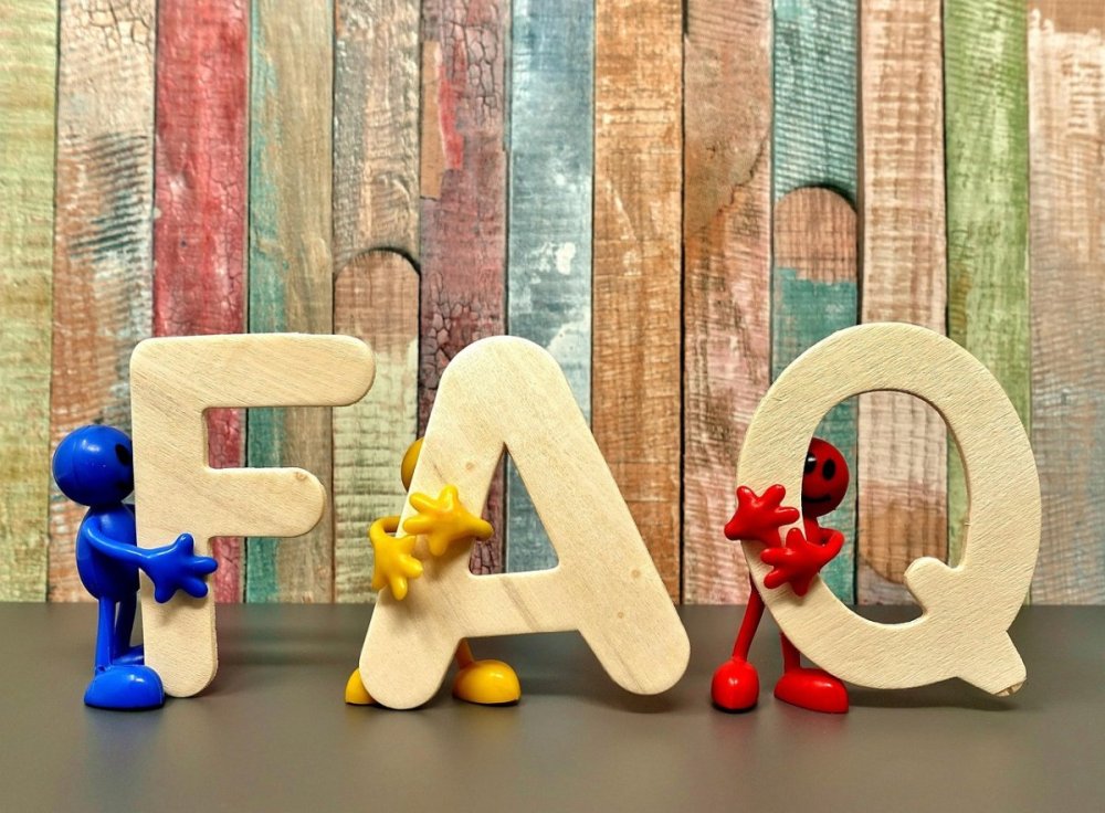 Three small cute monster things holding the letters F, A and Q.